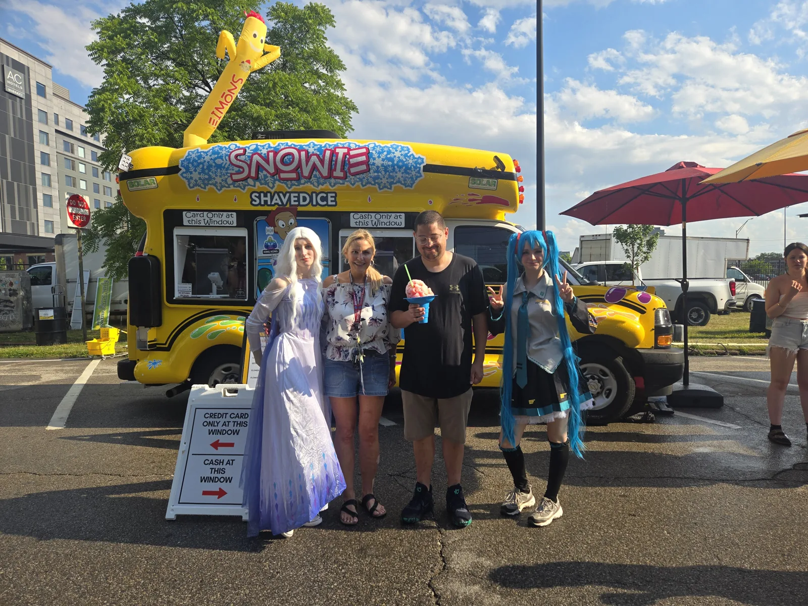 Tonia and family with costumed guests in front of the bus at a festival
